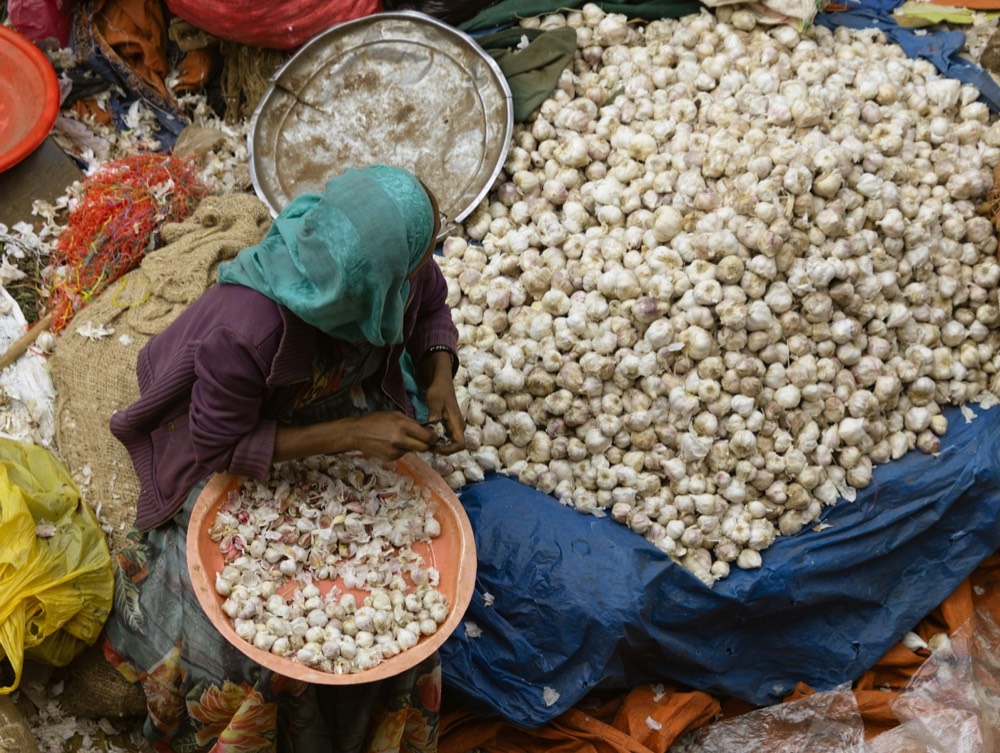 A trader sorting produce at a market stall